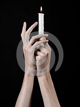 Hands holding a candle, a candle is lit, black background, solitude, warmth, in the dark, Hands death, hands witch