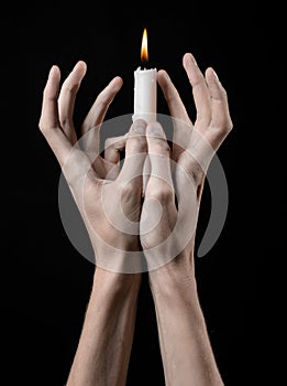 Hands holding a candle, a candle is lit, black background, solitude, warmth, in the dark, Hands death, hands witch