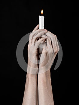 Hands holding a candle, a candle is lit, black background, solitude, warmth, in the dark, Hands death, hands witch