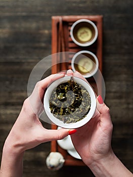 Hands holding Chawan tea bowl with green oolong