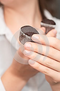 Hands Holding Chocolate Muffins. Presenting freshly baked chocolate muffins