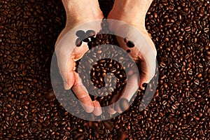 Hands holding coffee beans on beans background