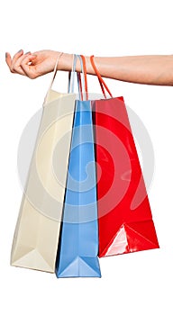 Hands holding colored shopping bags on white background