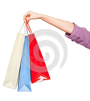 Hands holding colored shopping bags on white background