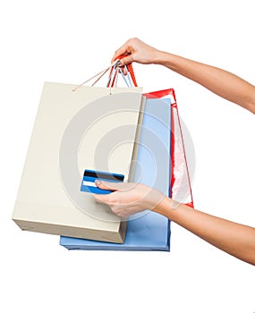 Hands holding colored shopping bags on white background