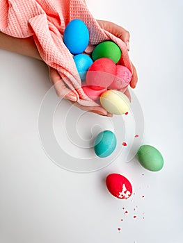 Hands holding colorful painted Easter eggs with one cracked egg on the side, representing Easter festivities, spring