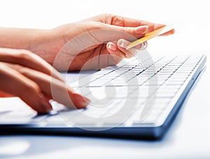 Hands holding credit card and using laptop computer for online shopping