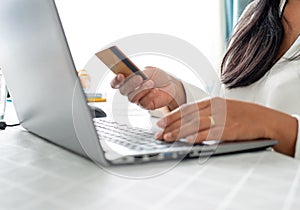 Hands holding credit card and using laptop. Online shopping