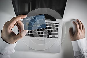 Hands holding credit card and using laptop. Online shopping photo