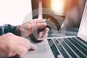 Hands holding credit card using Laptop payment shopping online with customer network connection via Omni channel system. Online sh