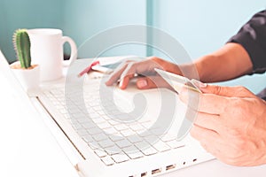 Hands holding credit cards and using laptop. Officer and business