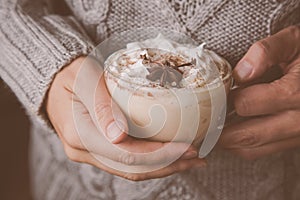 Hands holding cup of chai latte