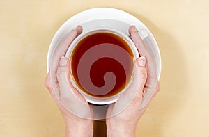 Hands holding cup of tea