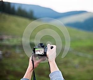 Hands holding the digital photo camera