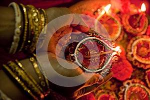 Hands holding Diwali lamps