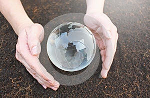 Hands holding earth made from glass