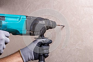 Hands holding electric drill in room, home renovation DIY concept