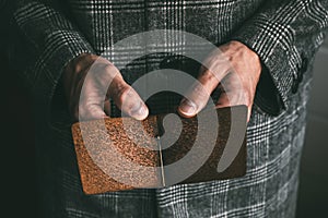 hands holding an empty brown leather money clip