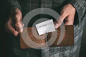 hands holding an empty brown leather money clip with the inscription coronavirus