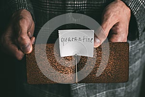 hands holding an empty brown leather money clip with the inscription quarantine