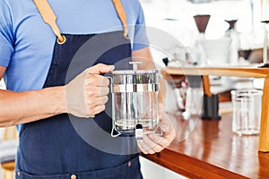 Hands holding french press coffee pot photo