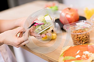 Hands holding Fresh fruits salad in box