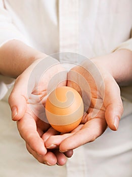 Hands holding a fresh organic egg