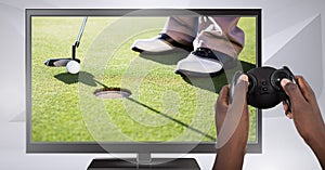 Hands holding gaming controller with golf player on television