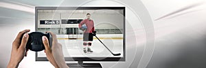 Hands holding gaming controller with hockey player on television