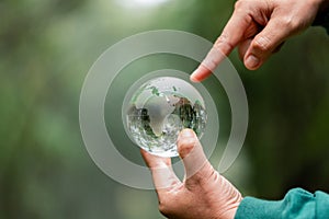 Hands Holding Globe Glass In Green Forest. Forest conservation concept. Environment Concept. elements of this image furnished by