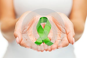 Hands holding green awareness ribbon