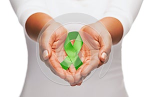 Hands holding green awareness ribbon