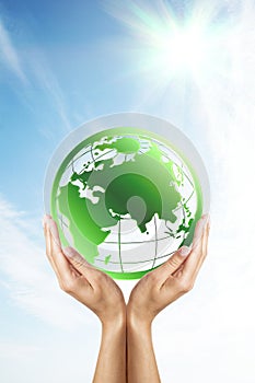 Hands holding a green planet (Earth)