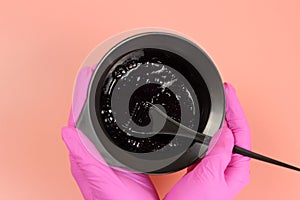 Hands holding hair dye in a bowl