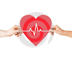 Hands holding heart with ecg line