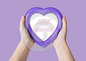 Hands holding heart with love yourself text. Self-respect and confidence concept