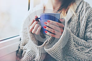 Hands holding hot cup of coffee or tea