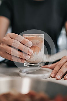 Hands holding hot cup of coffee or tea Close-up on background of a living room  with natural,