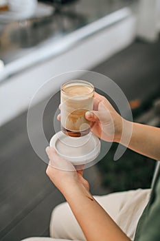 Hands holding hot cup of coffee or tea Close-up on background of a living room  with natural,