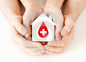 Hands holding house with donor sign