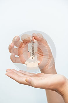 Hands holding house key on white background closeup - real state moving relocation concept