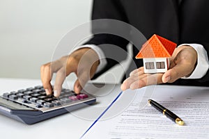 Hands holding a  house model. Housing industry mortgage plan and residential tax saving strategy, mortgage, investment, real