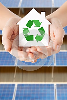 Hands holding house with recycling symbol