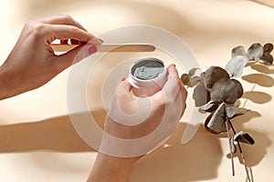 hands holding jar of blue cosmetic clay mask