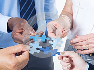 Hands Holding a Jigsaw with Business Concepts