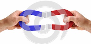 Hands holding magnets one red and one blue