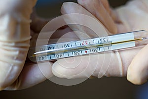 Hands holding medical thermometer