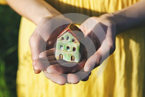 Hands holding model of house