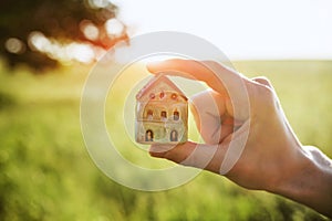 Hands holding model of house as