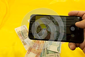 Hands holding modern mobile telephone dollar and euro symbols flaying away E-business concept